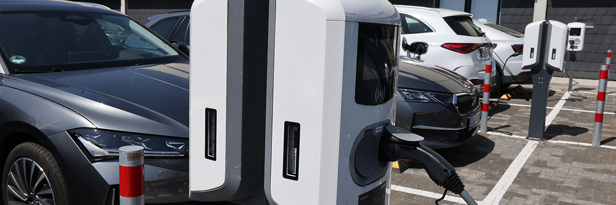 Elektroautos laden an mehreren Ladesäulen auf einem Piepenbrock-Parkplatz